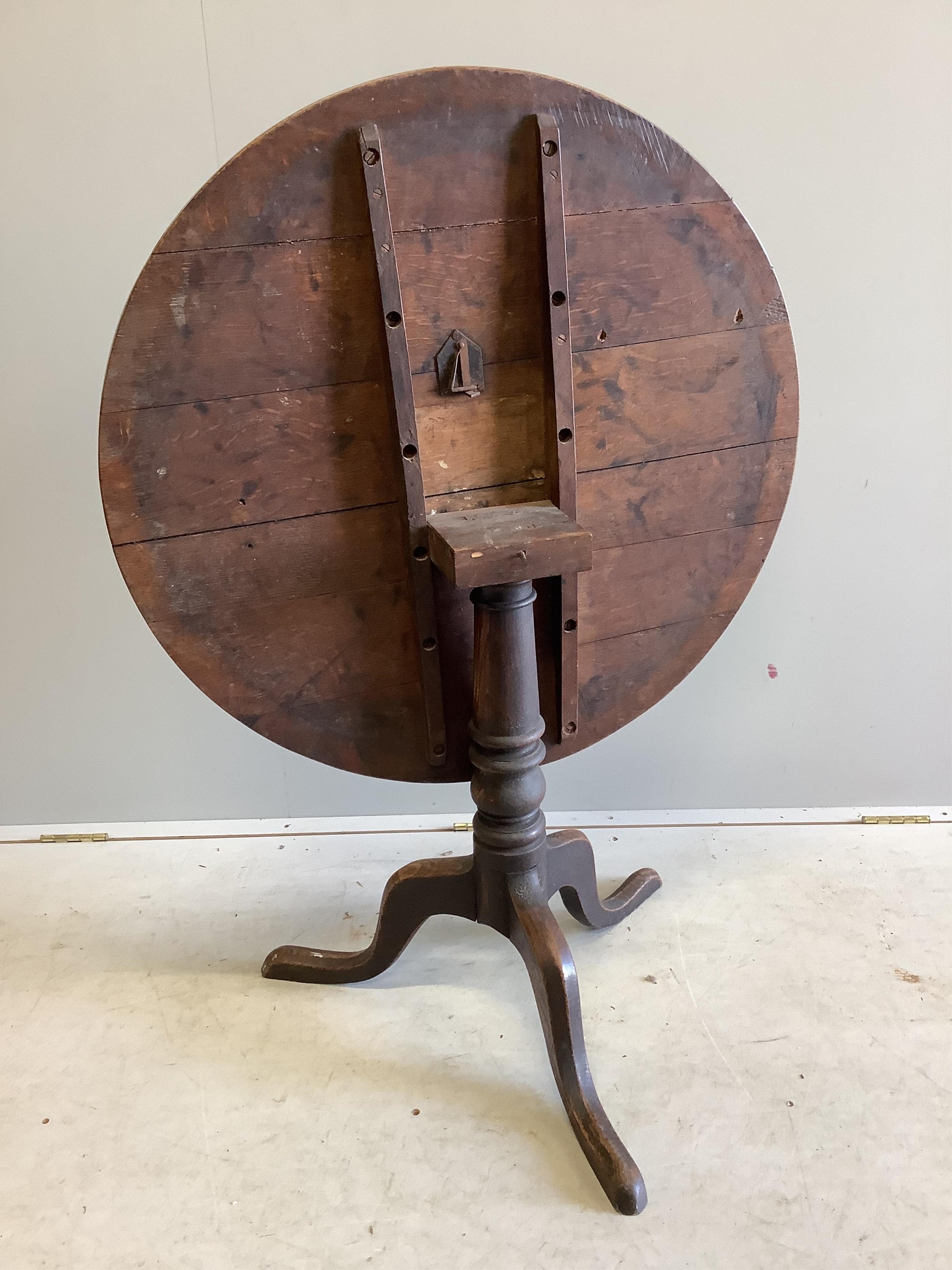 A George III circular oak tilt top tripod table, diameter 82cm, height 70cm. Condition - fair